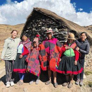shaman family in front of stone house